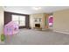 Spacious bonus room with carpet, TV, and playful decor offers versatility and room for Gathering activities at 419 Dovetree Dr, Danville, IN 46122