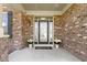 Charming covered front porch with brick accents, decorative plants and a welcoming glass front door at 419 Dovetree Dr, Danville, IN 46122