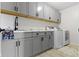 Laundry room featuring gray cabinets, marble countertops, a sink, and a washer and dryer at 419 Dovetree Dr, Danville, IN 46122
