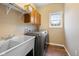 Laundry room featuring a utility sink, modern washer and dryer set, and convenient overhead storage cabinets at 442 Athens Pl, Westfield, IN 46074