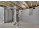 The unfinished basement features painted walls, utilities, and exposed ductwork at 451 N Gray St, Indianapolis, IN 46201