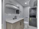 Modern bathroom features a stackable washer and dryer, marble vanity, and stylish mirror at 451 N Gray St, Indianapolis, IN 46201