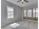 Bright bedroom with hardwood floors, multiple windows, and a ceiling fan at 451 N Gray St, Indianapolis, IN 46201