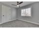 Bedroom features a ceiling fan, neutral carpet, light gray walls, and a window with backyard views at 451 N Gray St, Indianapolis, IN 46201