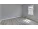 A bright bedroom featuring wood-look flooring, light gray walls, and a window with lots of natural light at 451 N Gray St, Indianapolis, IN 46201