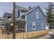 Attractive blue siding home with a covered front porch and picket fence, blending charm and curb appeal at 451 N Gray St, Indianapolis, IN 46201