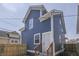 Charming home featuring blue siding, white trim, and a fenced-in backyard with a small patio at 451 N Gray St, Indianapolis, IN 46201