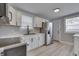 Well-lit kitchen with white cabinets, light countertops, stainless steel appliances, and gray walls at 451 N Gray St, Indianapolis, IN 46201