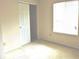 Bright bedroom features a window, neutral walls, carpet, and closet with sliding doors at 4959 Clarkson Dr, Indianapolis, IN 46254