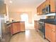 A kitchen features tile flooring, wood cabinets, stainless-steel appliances, and a view into the dining and living area at 4959 Clarkson Dr, Indianapolis, IN 46254