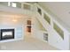 Cozy living room with fireplace, built-in shelving, staircase with glass, and a view into the kitchen at 4959 Clarkson Dr, Indianapolis, IN 46254