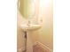 Powder room with pedestal sink, round mirror, and tile flooring at 4959 Clarkson Dr, Indianapolis, IN 46254
