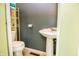 Compact bathroom with a classic pedestal sink, toilet, and shelving for storage, designed for functionality at 504 W Dwain, Shelbyville, IN 46176