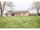 A well-maintained single-story home with a brick facade, a welcoming front porch, and a lush green lawn at 504 W Dwain, Shelbyville, IN 46176