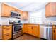 A kitchen that is equipped with wooden cabinets, stainless steel appliances, and a bright, window-lit space at 504 W Dwain, Shelbyville, IN 46176