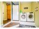 Bright laundry room with a full-size refrigerator and washer and dryer sets, offering convenience and functionality at 504 W Dwain, Shelbyville, IN 46176
