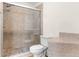 Modern tiled shower with glass door complemented by an updated toilet and neutral color palette at 5105 Hawks Crescent Ct, Indianapolis, IN 46254