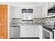 Kitchen showcasing white cabinets, stainless steel appliances, sink, and tile backsplash at 5105 Hawks Crescent Ct, Indianapolis, IN 46254