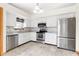 Charming kitchen with stainless steel appliances, white cabinets, and modern tile floors at 5105 Hawks Crescent Ct, Indianapolis, IN 46254
