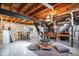 Large basement featuring exposed beams, concrete floor, open recreational space, bar, and utilitarian decor at 5277 Kingsley Dr, Indianapolis, IN 46220