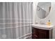 Clean bathroom with a round mirror and vanity, complemented by a white shower curtain at 5277 Kingsley Dr, Indianapolis, IN 46220