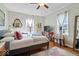 Bedroom features hardwood floors, a comfortable bed, vintage furniture, and stylish decor with modern tv at 5277 Kingsley Dr, Indianapolis, IN 46220
