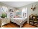 Bright bedroom featuring hardwood floors, a bed with decorative pillows, and two large sunny windows at 5277 Kingsley Dr, Indianapolis, IN 46220