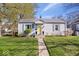Charming single-story home featuring a well-maintained lawn, inviting yellow front door and blue shutters at 5277 Kingsley Dr, Indianapolis, IN 46220