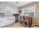 Charming kitchen with white cabinets, stainless steel appliances, a mosaic backsplash, tiled floors, and a breakfast bar at 5277 Kingsley Dr, Indianapolis, IN 46220