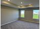 Spacious main bedroom with tray ceiling, carpeted floor, and bright windows with views of the neighborhood at 5692 Coulter Way, Greenwood, IN 46143