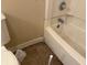 Bathroom with a toilet, bathtub, and beige tiled floor at 605 Queenswood Dr, Indianapolis, IN 46217