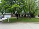 Charming brick home with a well-maintained lawn and mature trees offering shade and curb appeal at 605 Queenswood Dr, Indianapolis, IN 46217