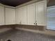 Kitchen featuring damaged white cabinets, gray countertops and a window at 605 Queenswood Dr, Indianapolis, IN 46217