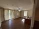 Spacious living room with ceiling fan, wood floors, and sliding glass door with striped curtains at 605 Queenswood Dr, Indianapolis, IN 46217