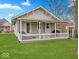 Spacious backyard featuring a covered porch with white picket fence at 614 Elm St, Shelbyville, IN 46176