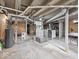 Unfinished basement featuring painted support beams, concrete floor, and included washer and dryer at 614 Elm St, Shelbyville, IN 46176
