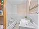 Clean bathroom featuring white tile, a bathtub with a safety seat, and a modern sink at 614 Elm St, Shelbyville, IN 46176