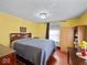 Bright bedroom featuring yellow walls, hardwood floors, a large bed, and ample closet space at 614 Elm St, Shelbyville, IN 46176