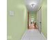 Bright hallway with green walls, tiled floors, and a decorative mirror reflecting into the adjacent living space at 614 Elm St, Shelbyville, IN 46176