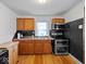 Well-lit kitchen with wooden cabinetry, stainless steel appliances, and hardwood floors at 614 Elm St, Shelbyville, IN 46176