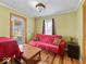 Cozy living room featuring hardwood floors, a red sofa, and a sliding glass door to the outside at 614 Elm St, Shelbyville, IN 46176