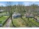 Aerial view of a single-story home with gray siding and a long driveway, surrounded by mature trees at 6303 Bertha St, Indianapolis, IN 46241
