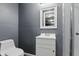 Bathroom features a modern vanity and sink next to the toilet and glass door shower at 6303 Bertha St, Indianapolis, IN 46241