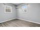 A simple room with gray flooring, two windows, and a corner shelf at 6303 Bertha St, Indianapolis, IN 46241