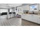 Modern kitchen features white cabinets, wood floors, a bay window, and an open bar area to living room at 6303 Bertha St, Indianapolis, IN 46241