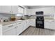 A modern kitchen featuring white cabinets, stainless steel appliances, and gray flooring at 6303 Bertha St, Indianapolis, IN 46241