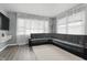 Bright living room with gray walls, laminate flooring, and a large sectional sofa, creating a welcoming space at 6303 Bertha St, Indianapolis, IN 46241