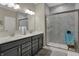 Bathroom with double sinks, gray cabinets, and tiled shower with glass door at 6625 Ferguson Dr, Whitestown, IN 46075