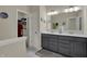 Bathroom featuring a double vanity with gray cabinets, large mirror, and walk-in closet at 6625 Ferguson Dr, Whitestown, IN 46075