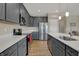 Spacious kitchen featuring gray cabinetry, stainless steel appliances, quartz counters, and hardwood flooring at 6625 Ferguson Dr, Whitestown, IN 46075